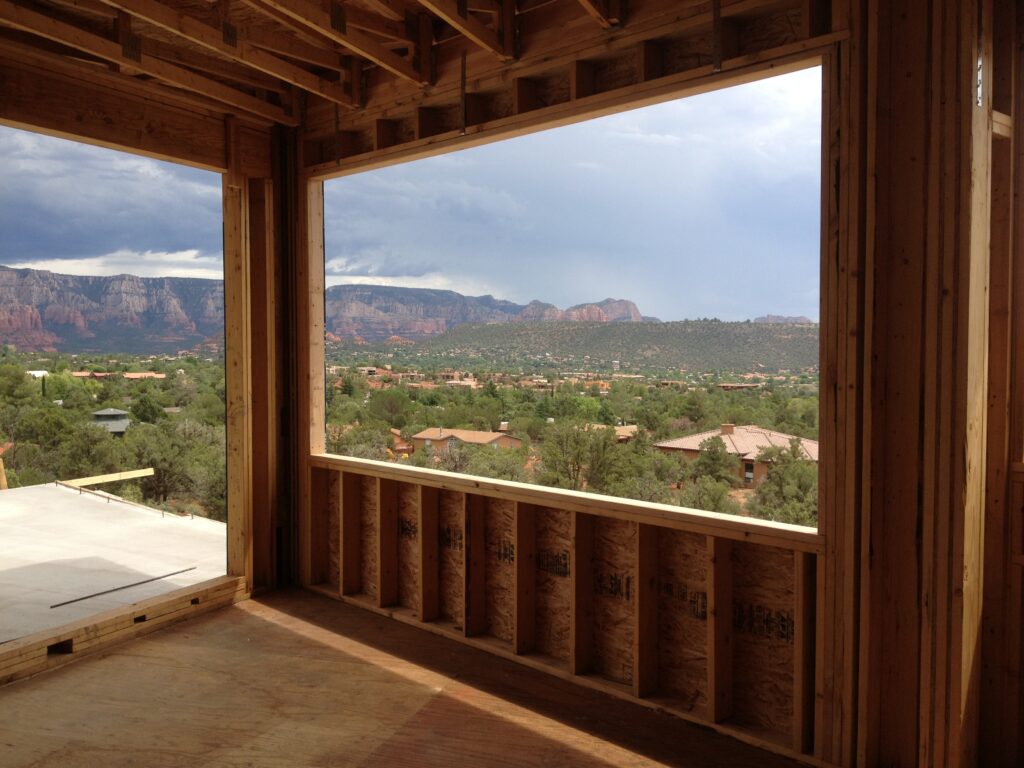 View of the Sedona red rocks through a rough-framed window opening in a Kirkwood Builders custom home