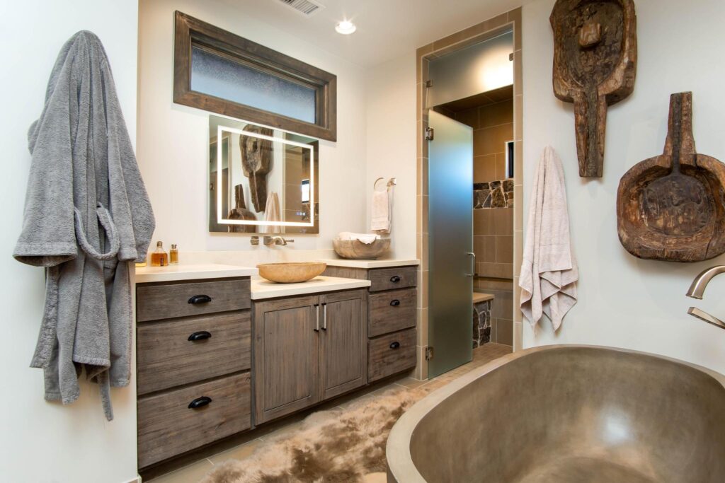 Bathroom with a stone basin, carved pieces on the wall and the tub beyond