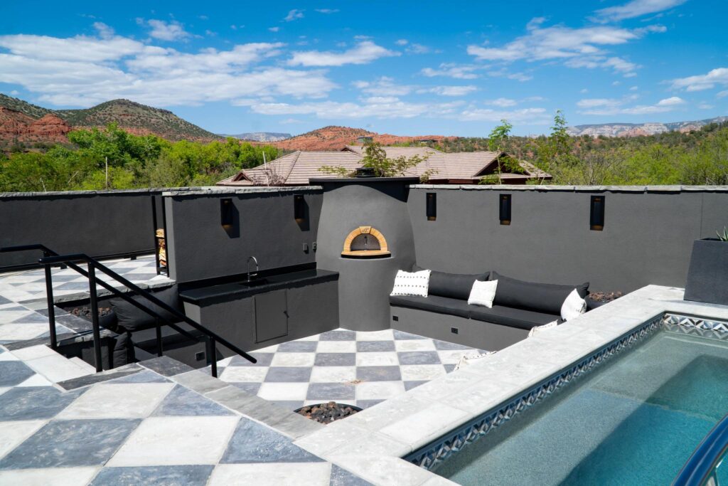 Pool terrace with a pizza oven, built-in seating and the checkerboard paving