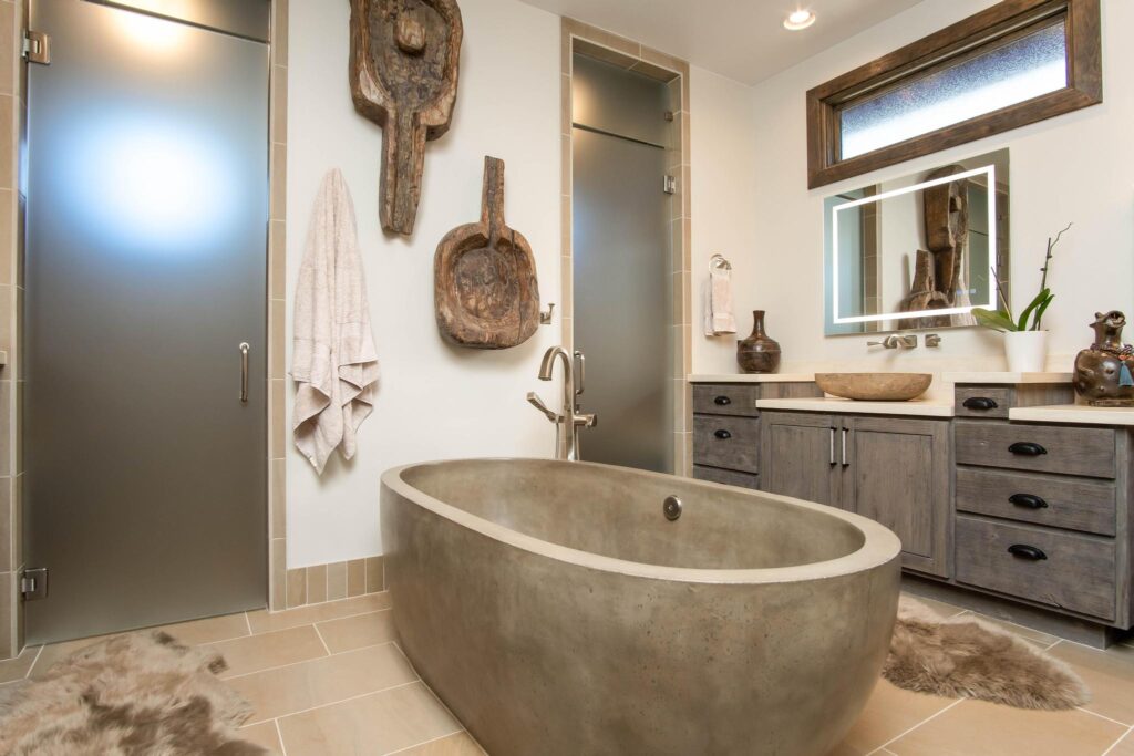 Primary bathroom with a stone freestanding tub between the shower and vanity