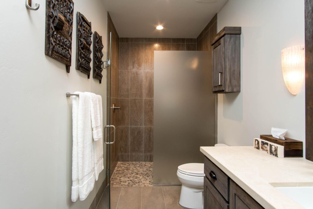 Guest bathroom with a walk-in shower and a carved panel on the wall