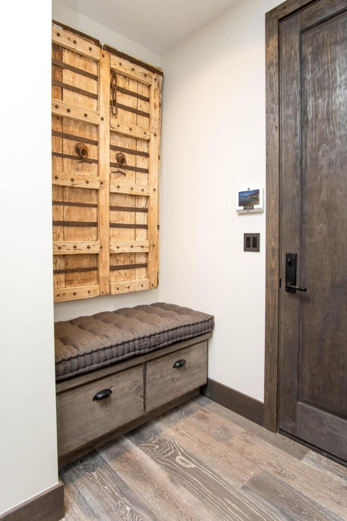 Carved timber panel hung above a bench beside the bedroom door