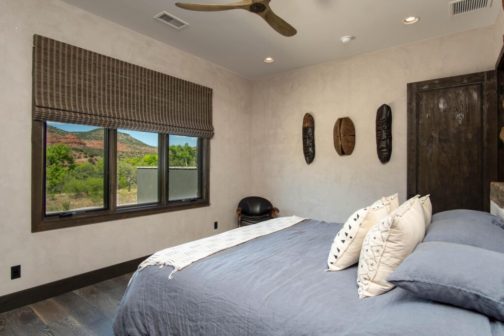 Bedroom with a window onto the desert and carved masks on the wall