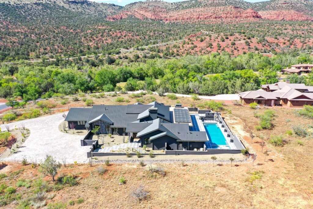 The property from a distance, sitting in the valley below the red rock