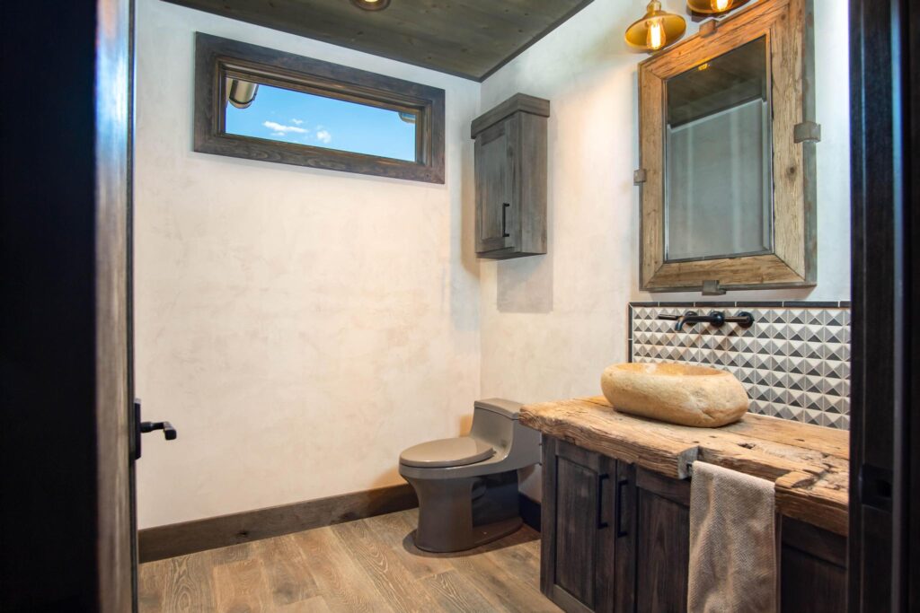 Powder room with a carved stone basin on a timber counter