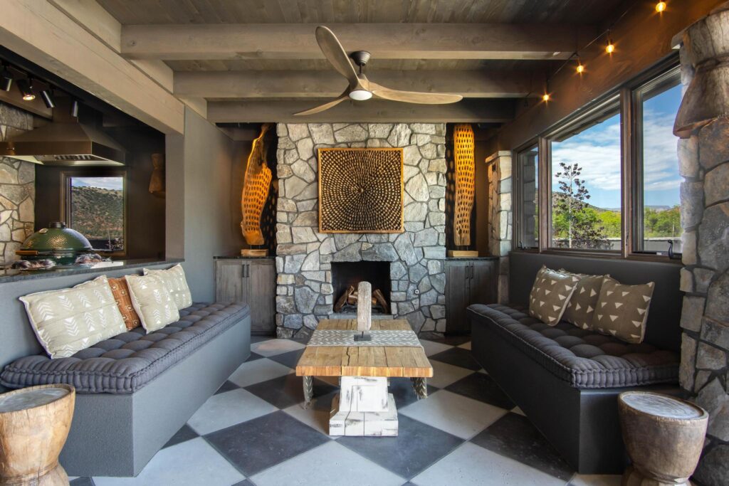 Outdoor kitchen with the grills built into the counter beside the fireplace