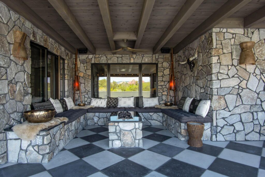 Built-in stone banquette running the corner of the pavilion, carved drums used as stools