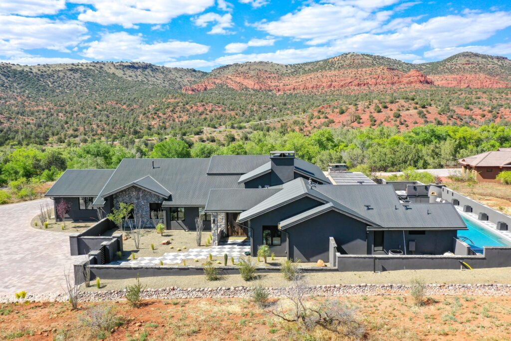 The house from the air with the pool terrace and the red rock behind