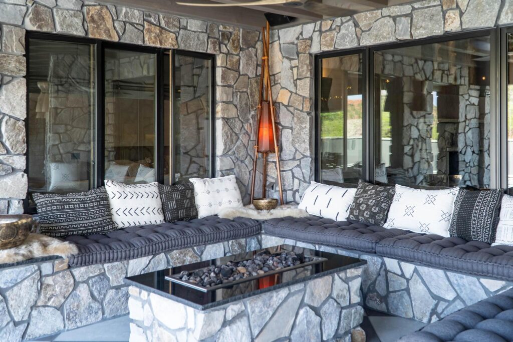 Built-in seating around a fire table under the stone wall