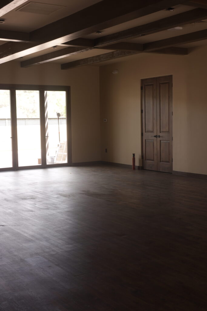 Room before fit-out, with French doors onto the balcony and the floor newly laid