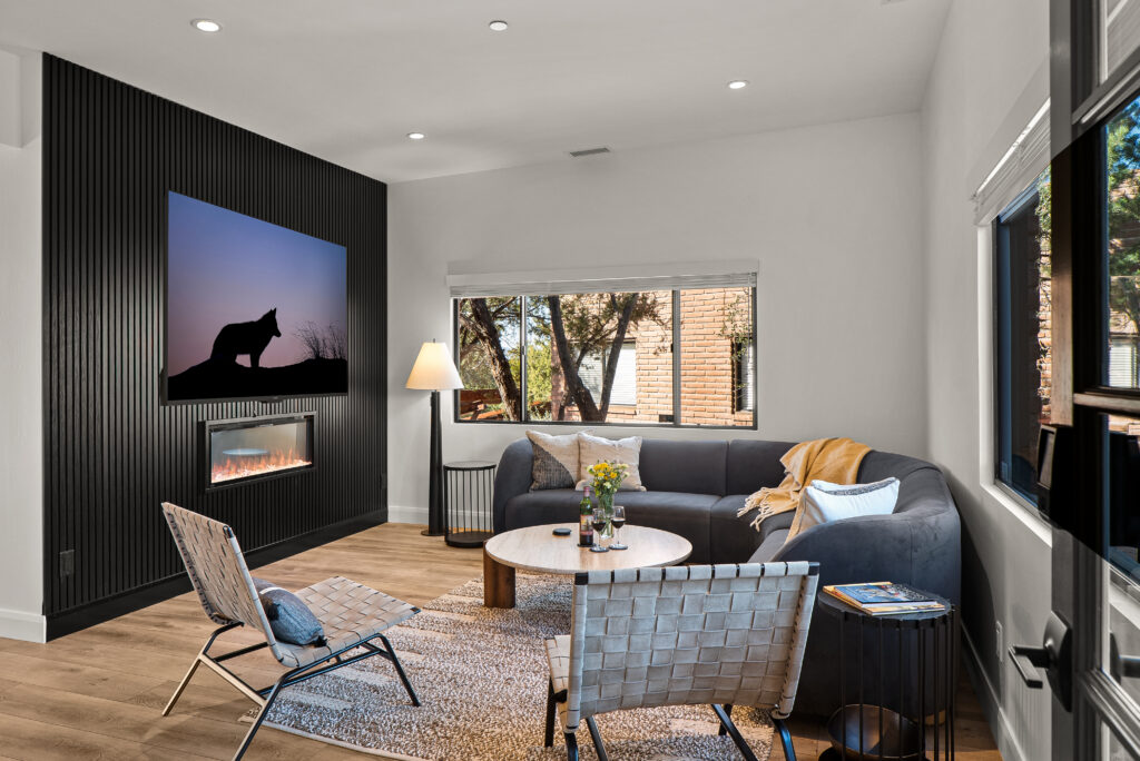 Living room at Agave Villas with a black vertical-slat accent wall, a linear fireplace, and a wall-mounted TV