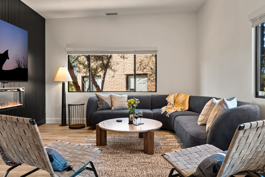 Sectional sofa, round coffee table, and woven leather chairs in the Agave Villas living room