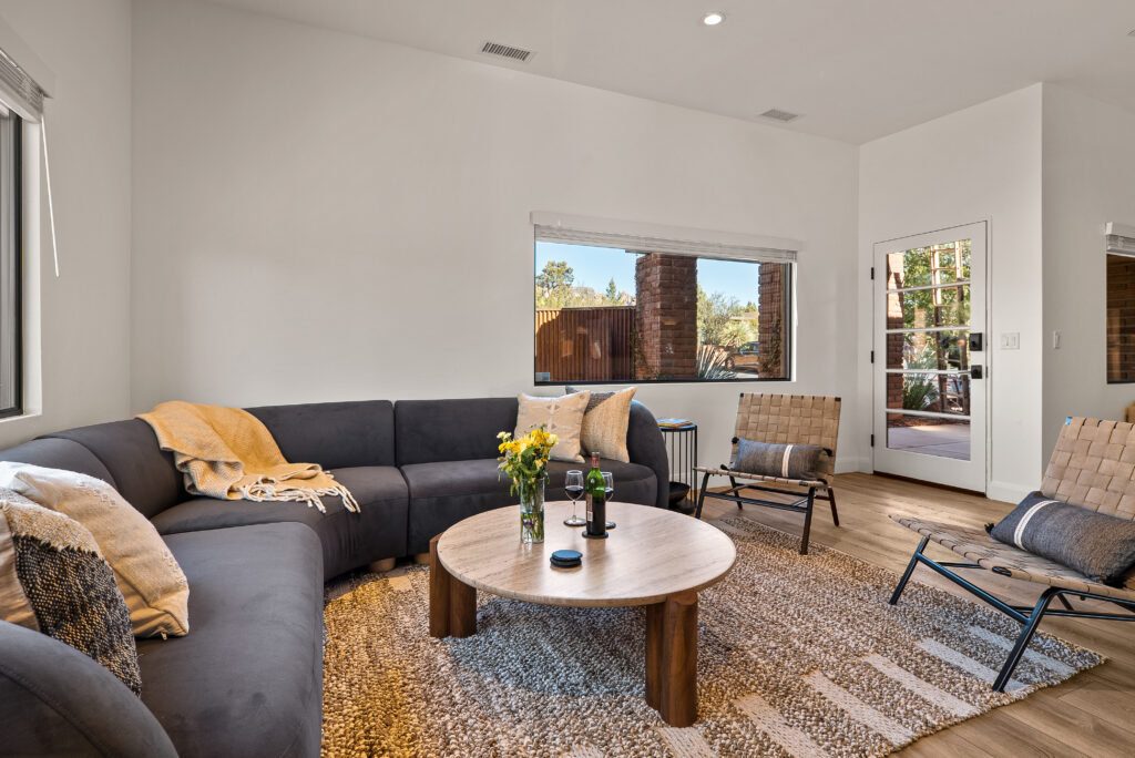 Open living area with a sectional sofa and a glass door out to the patio