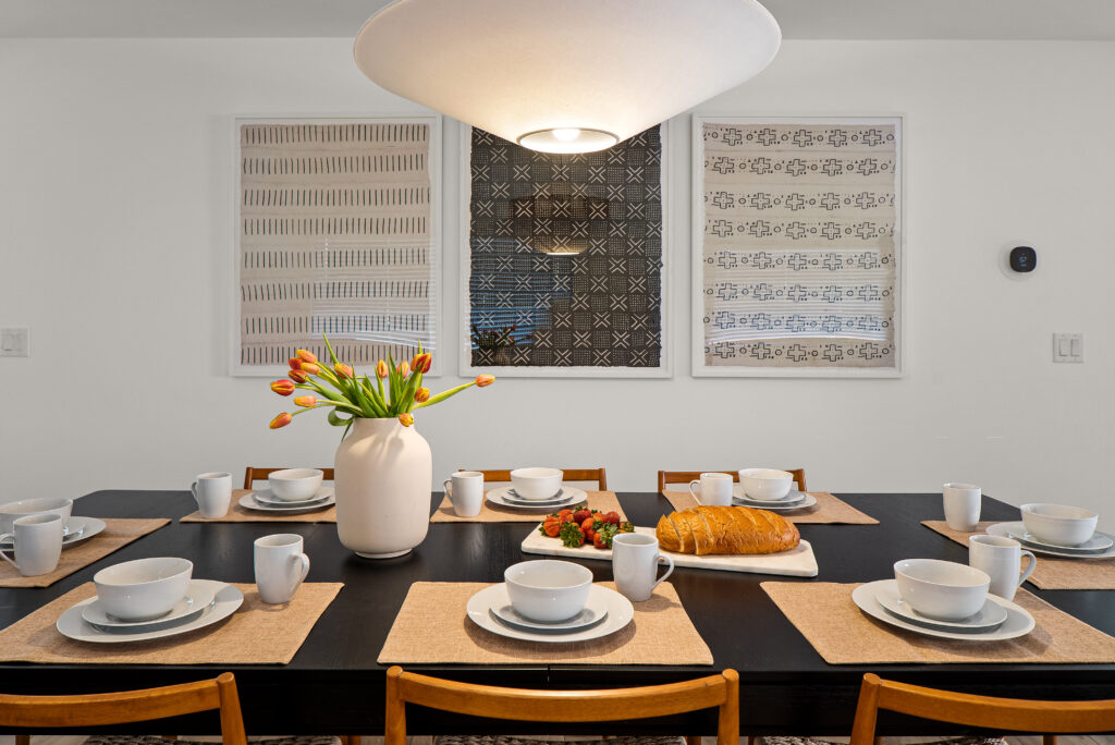 Dining table laid with place settings under a wide dome pendant at Agave Villas