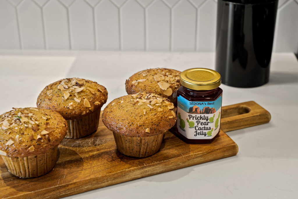 Muffins and a jar of Sedona prickly pear cactus jelly on a serving board on the kitchen counter