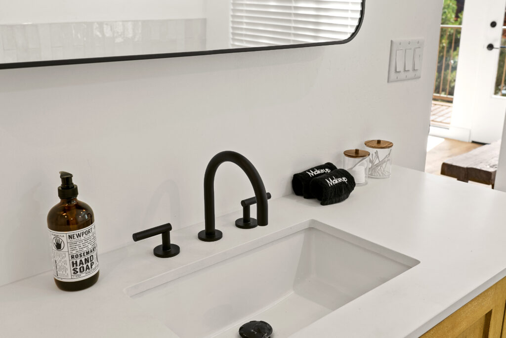 Close view of a bathroom vanity with a black faucet and an undermount sink