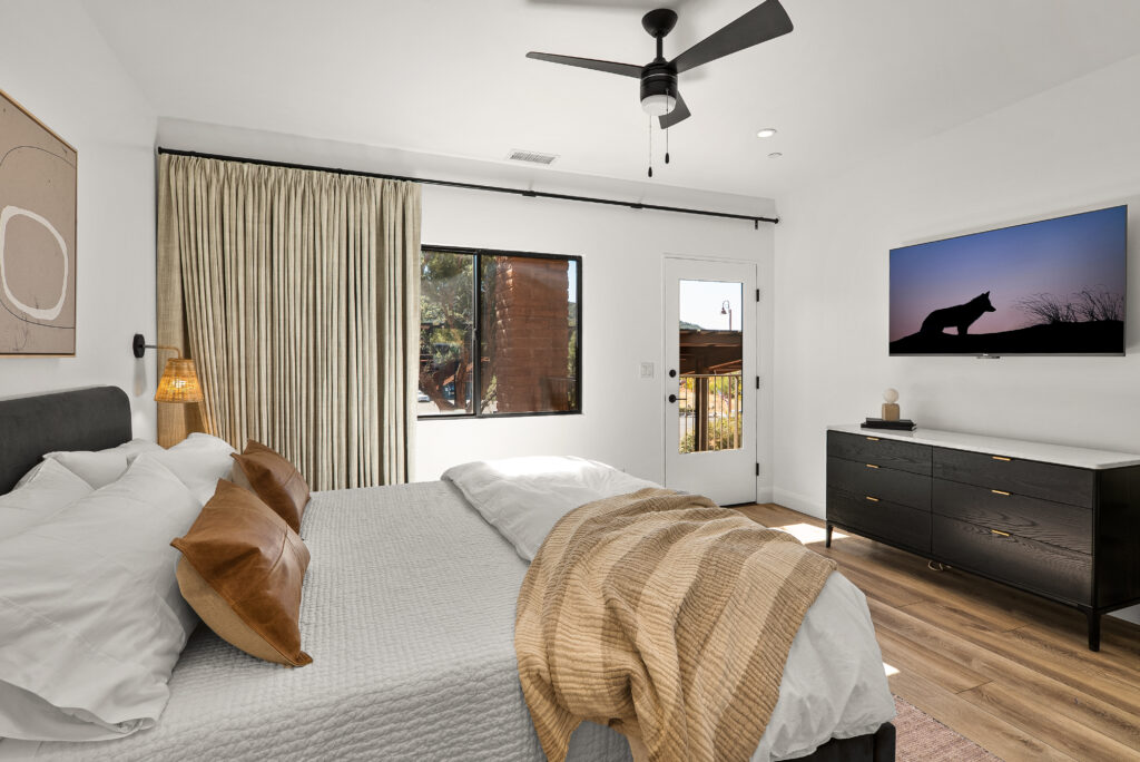 Bedroom at Agave Villas with a ceiling fan, dresser, and wall-mounted TV