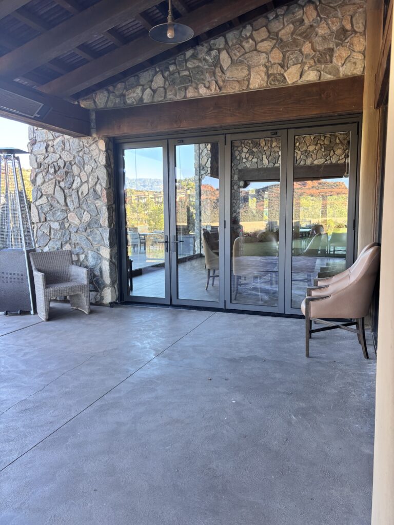 Stone column and sliding glass doors framing the view out from the terrace seating