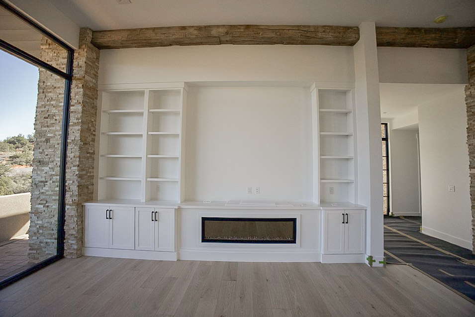 Built-in cabinetry and shelving around a linear fireplace
