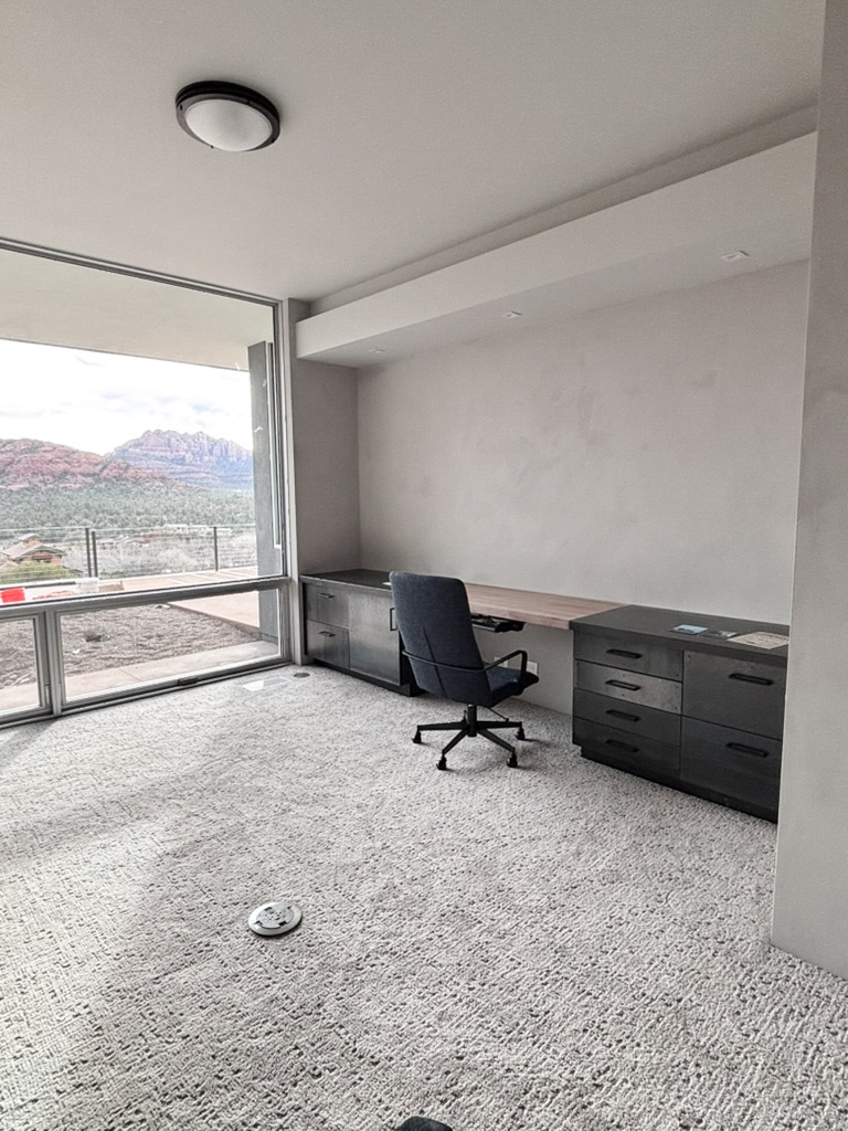 Study with a built-in desk run along a glazed corner facing the rocks
