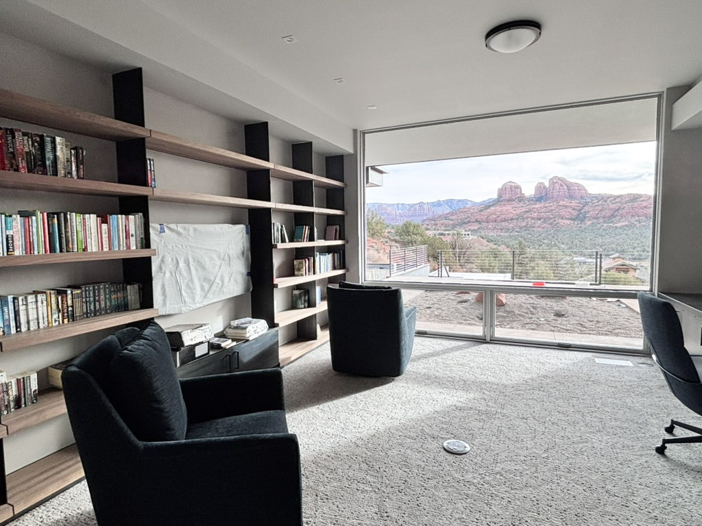 Library with timber shelving on both sides and a seating group by the window