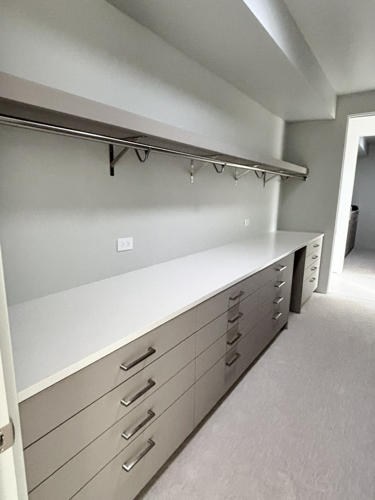 Dressing room with a long counter, drawer banks and a hanging rail above