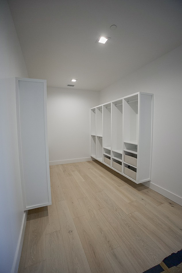 Walk-in closet fitted out with open shelving and drawer banks