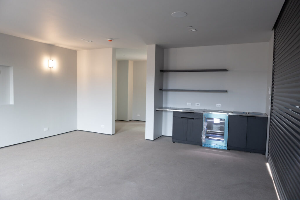 Room with a bar run along one wall beside the roller door