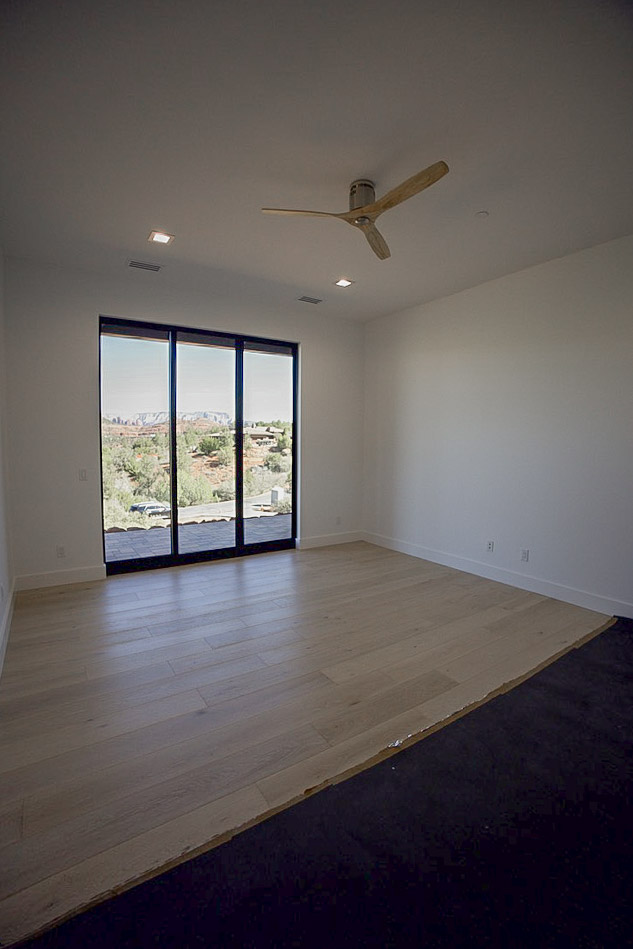 Bedroom opening through a full-height slider to the red rock view
