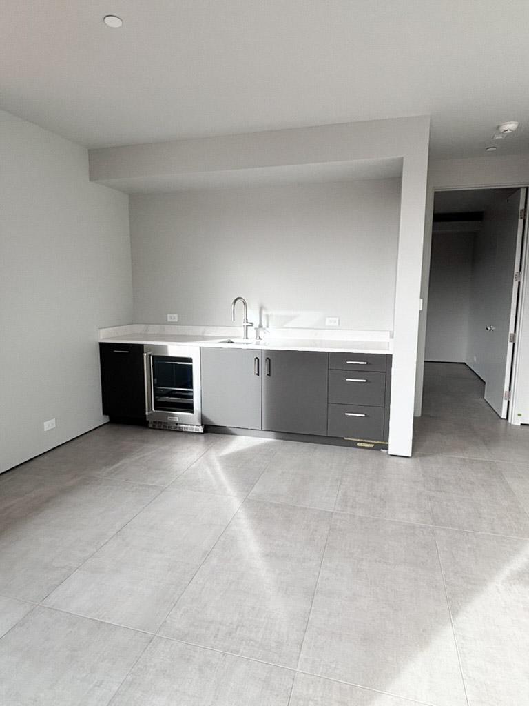 Wet bar with a sink and under-counter fridge set into the cabinetry