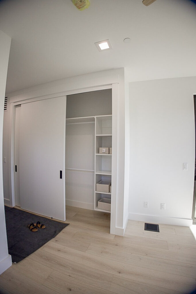 Linen closet behind sliding doors, shelved out