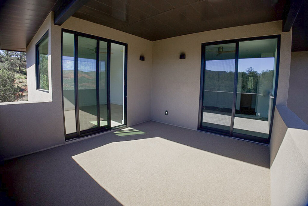 Covered deck under a timber ceiling, with sliding doors back into the house