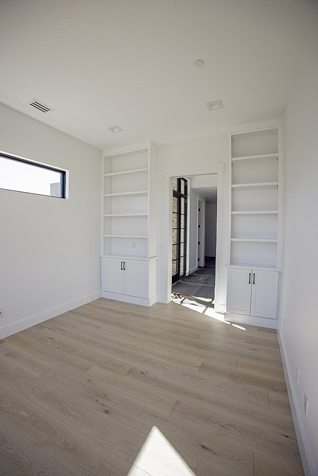 Built-in white shelving flanking a doorway, with a window to the side