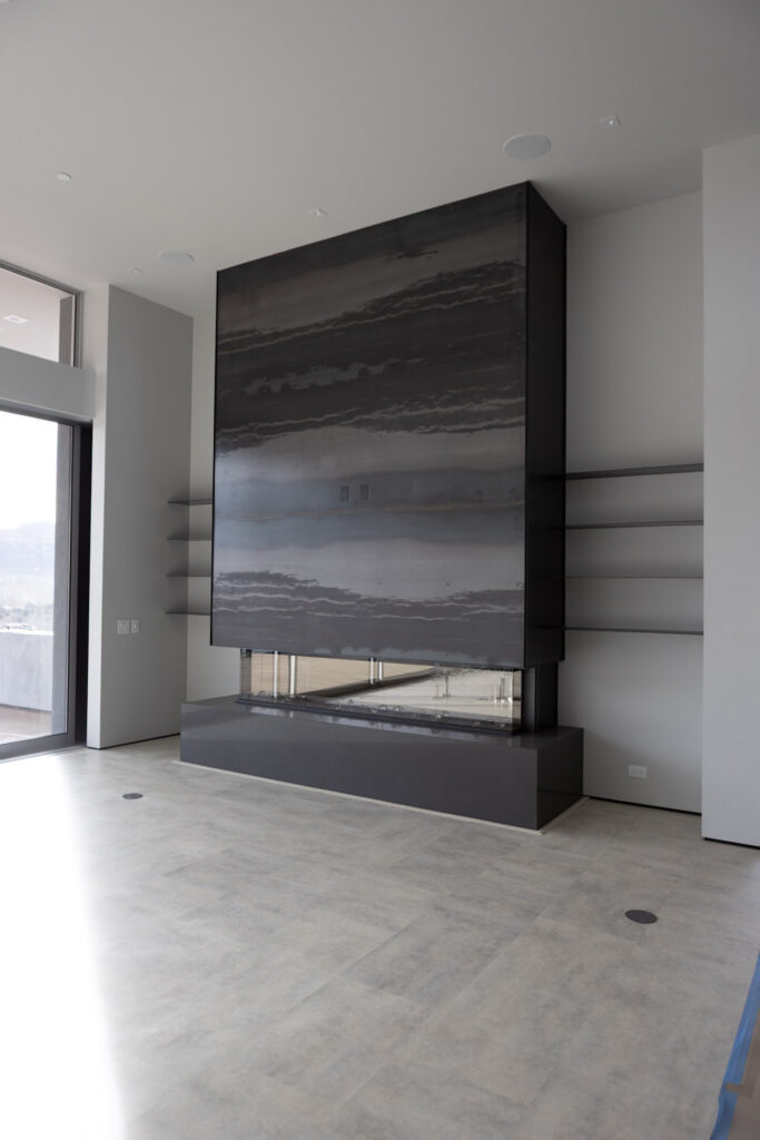 Linear fireplace set into a stone surround running floor to ceiling
