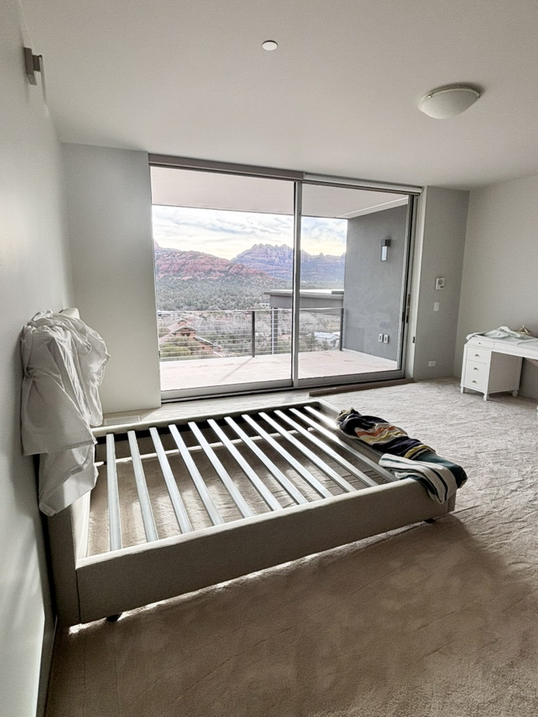 Bedroom with a slider onto the balcony and red rock across the valley