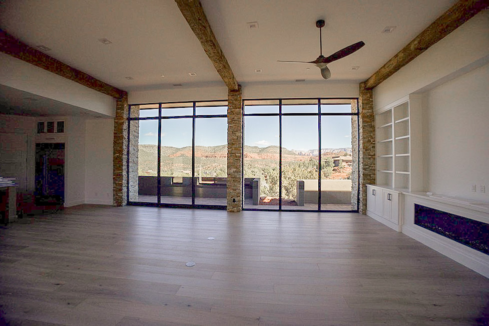 The main living space from the far end, glazed across its full width