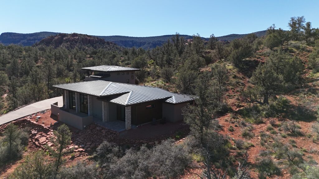 Star Ranch from above, low-slope metal roofs set among the junipers